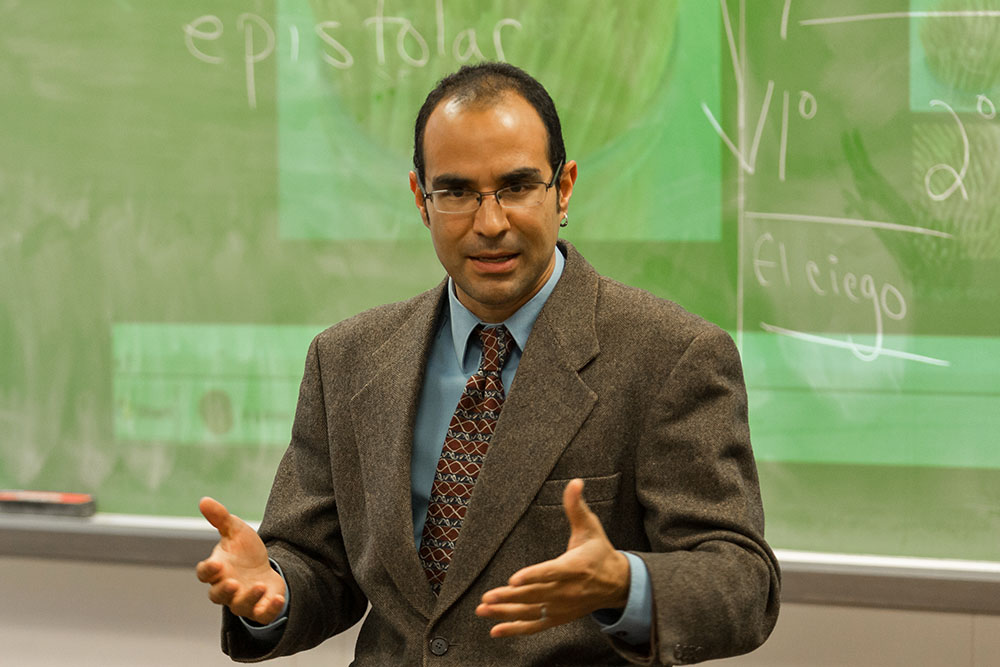 Professor speaking in front of chalkboard