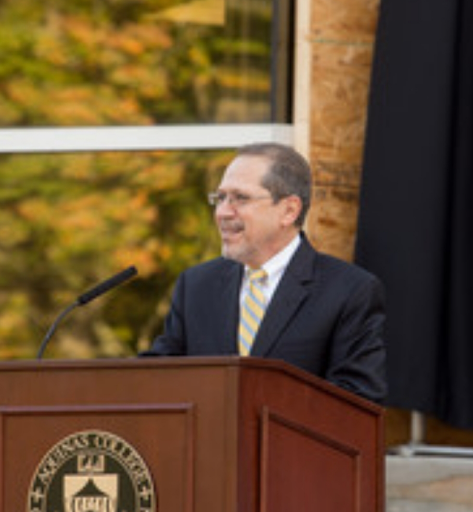 Juan Oliverez at a mic on a podium