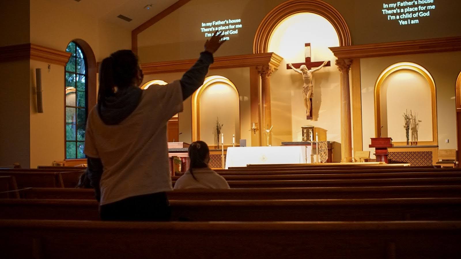 Back of student who has arm raised inside the Chapel