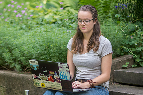 student working on laptop outside