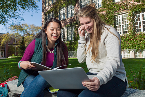 two students sitting on bench together