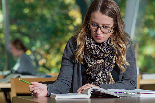 student at desk with book