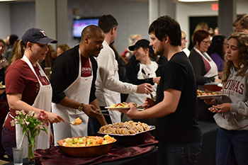workers in cafeteria serving food to students