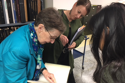 two women looking at book showing a student
