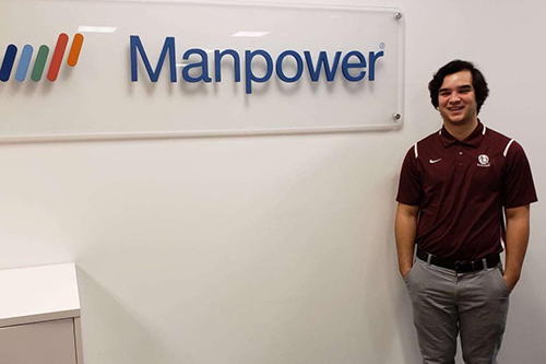 student in front of "Manpower" sign