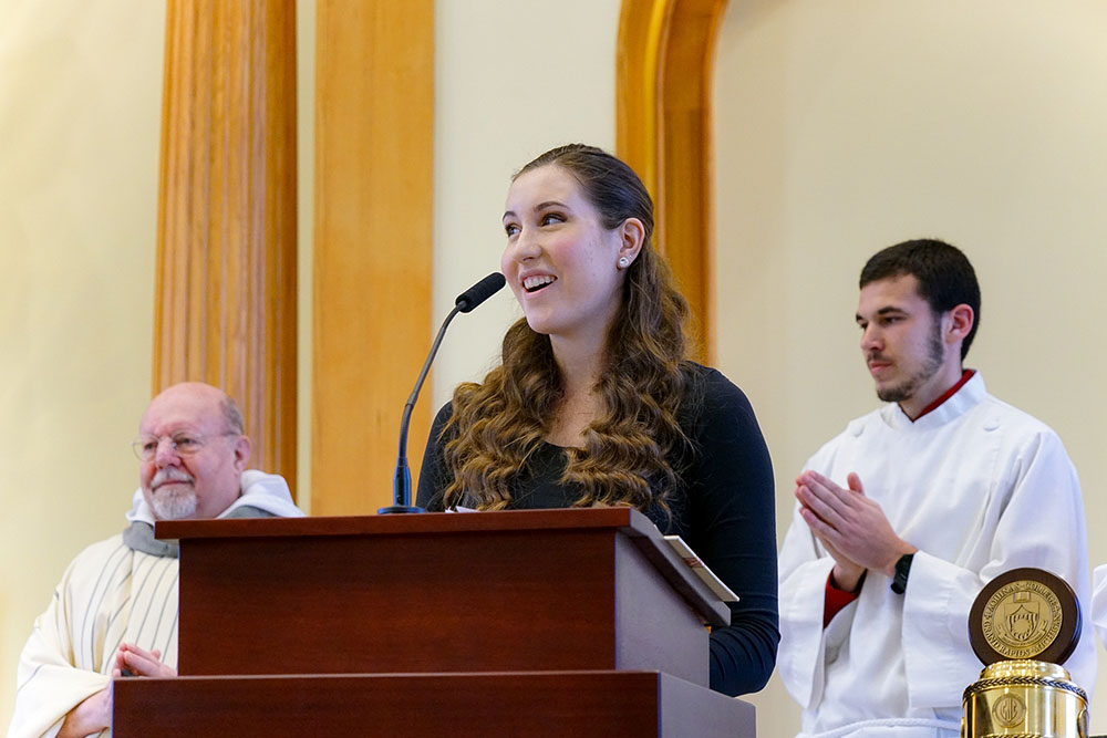 student standing at front of chapel