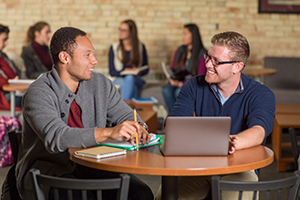 two students at table talking