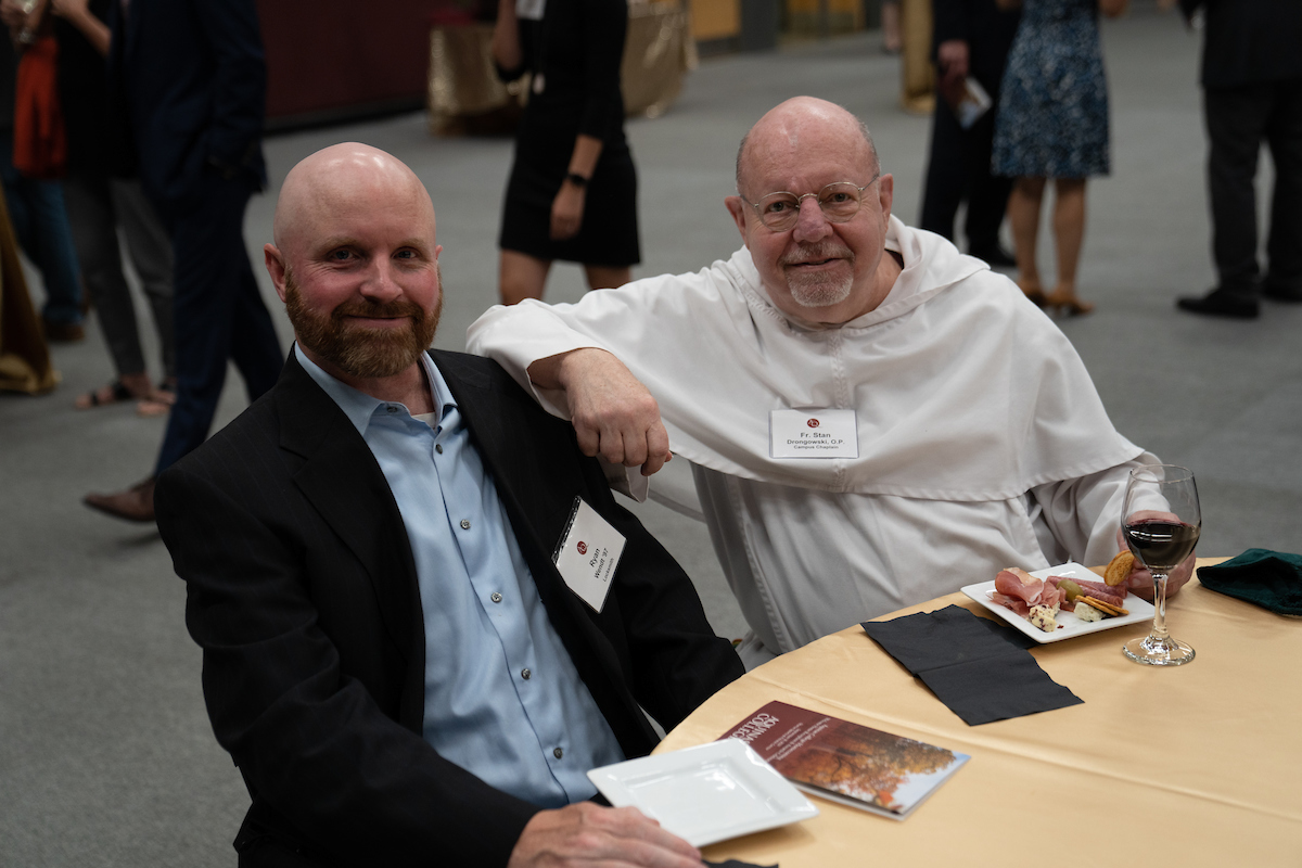 Fr Stan with Campus Safety's Ryan Wendt sitting at a table