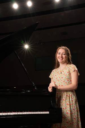 Lexi Schaub standing at piano