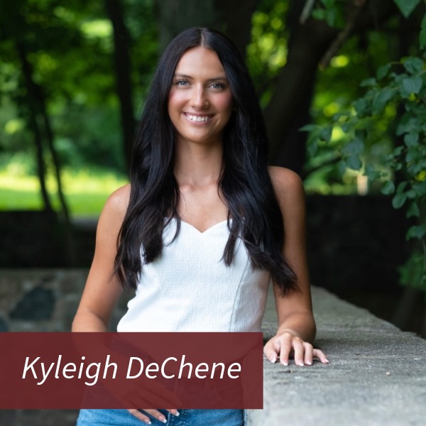 Photo of a girl with long, dark hair, next to a fence. Text reading: Kyleigh DeChene.