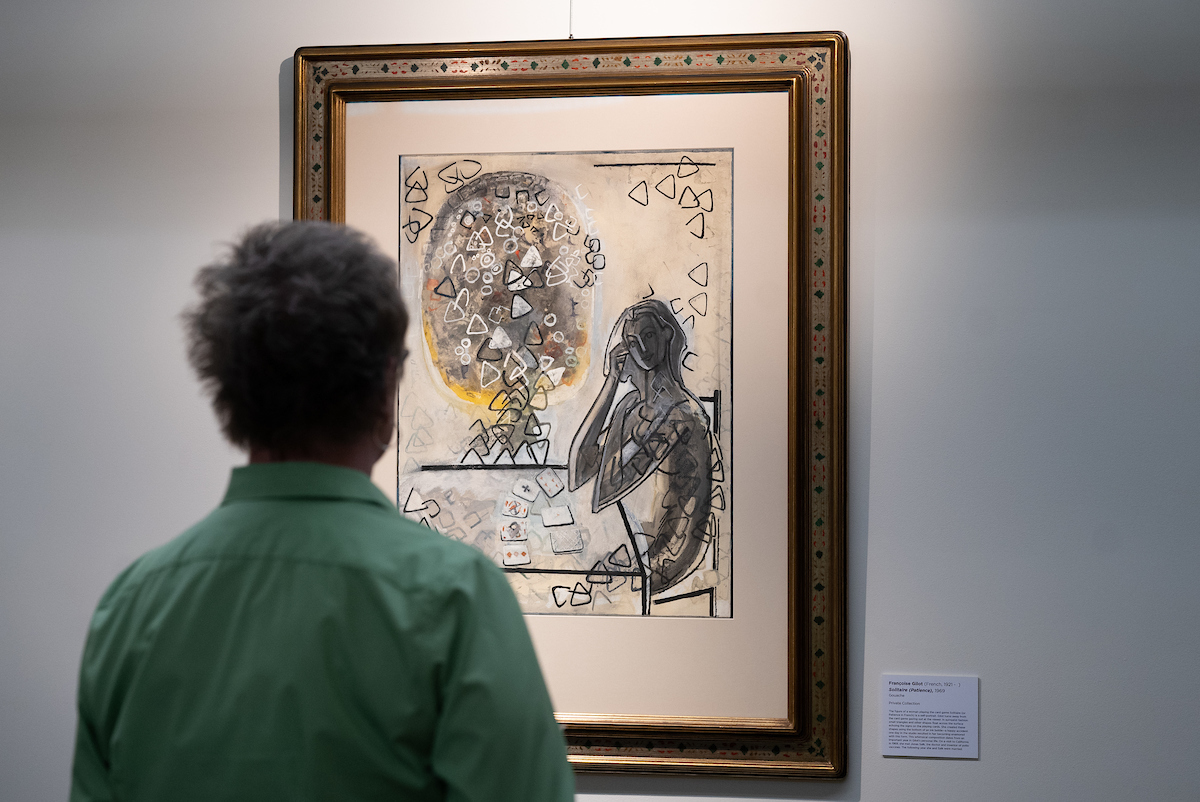 Person facing away from camera looks at art by Gilot