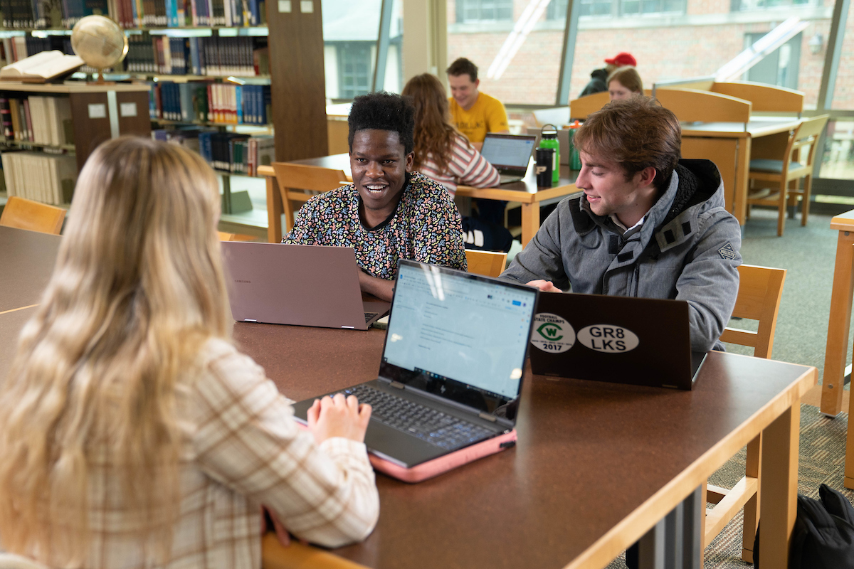 students with laptops at a table