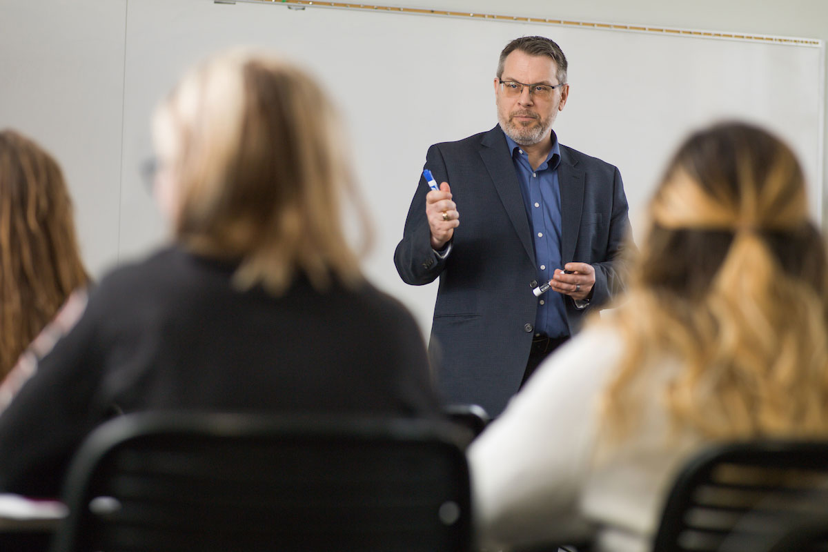 professor talking to students in a classroom