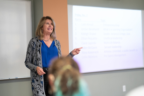 Professor Speaking at the front of a classroom