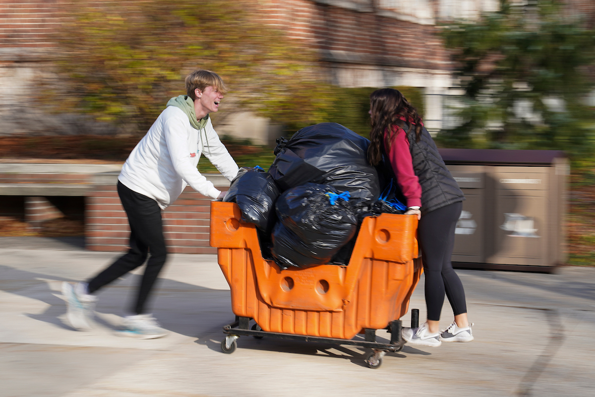 A student pushing a large cart full of donations