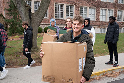 Students loading boxes of goods onto trucks