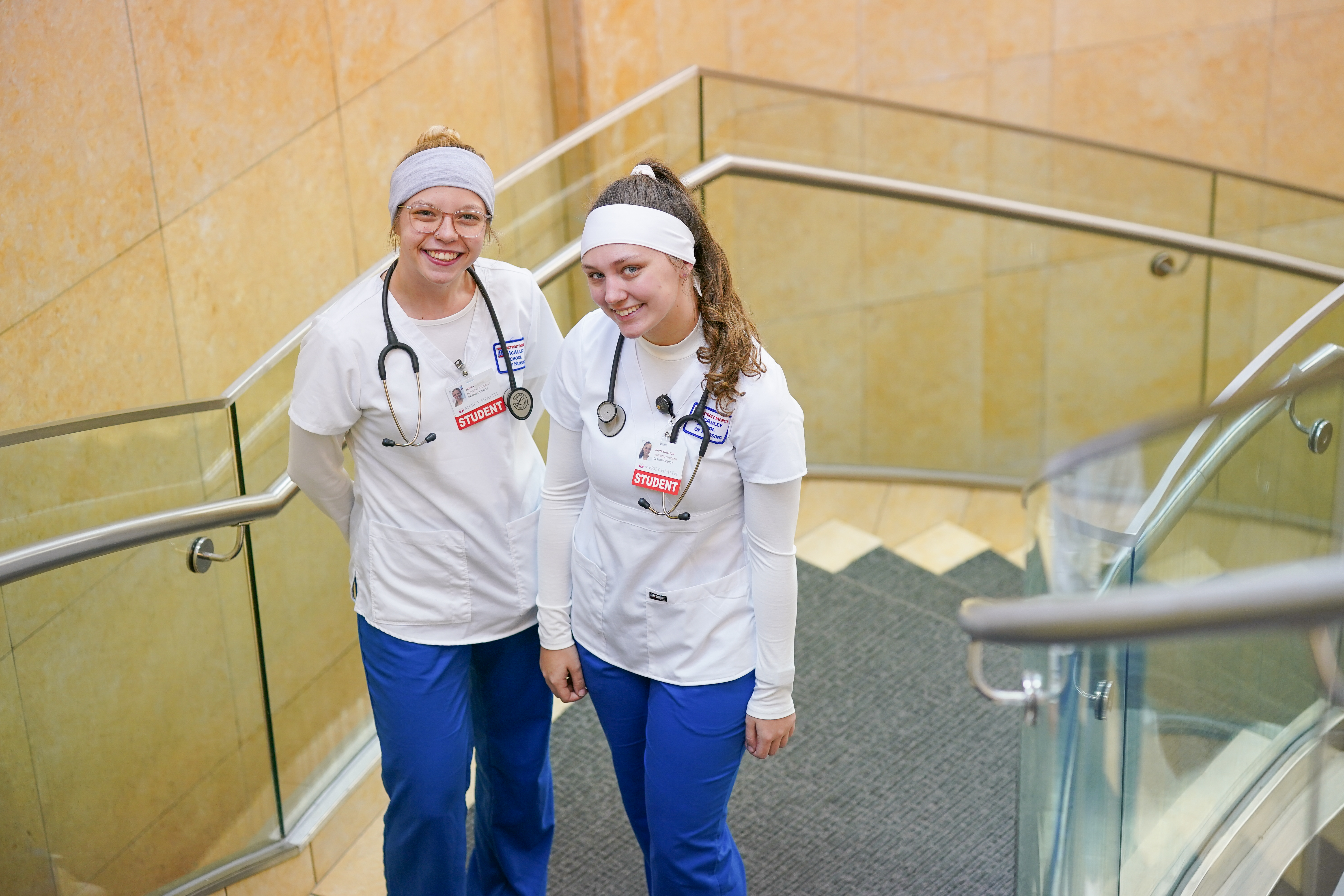 Two students in scrubs smiling