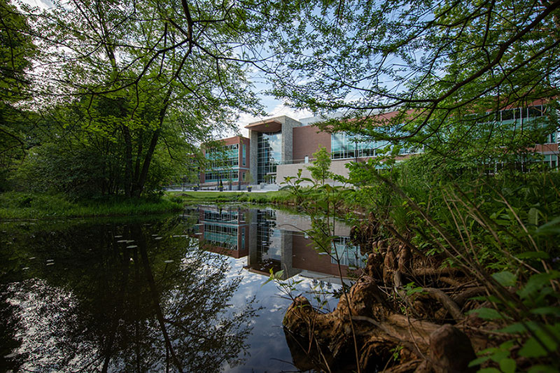 Science building with pond and foliage
