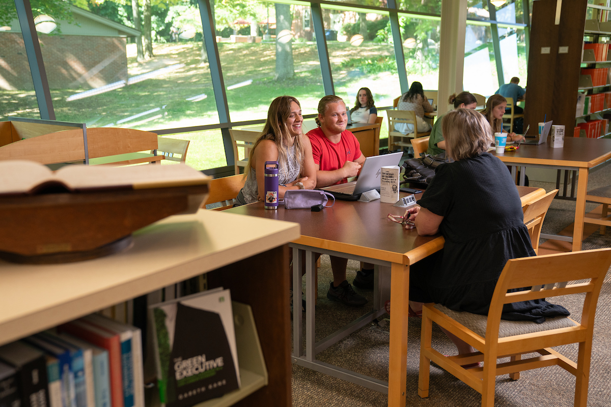 Sara Haviland at a table in the library, smiling and talking