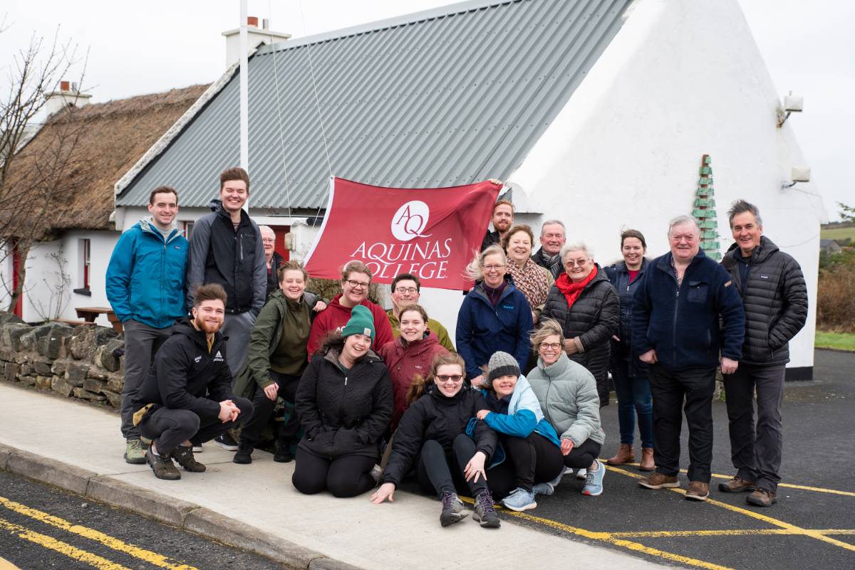 People pose in front of Aquinas Flag in Ireland