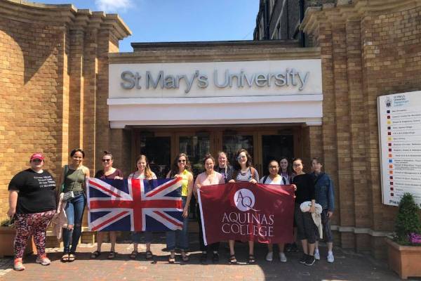 Students in front of St. Mary's University with an Aquinas flag and British Flag