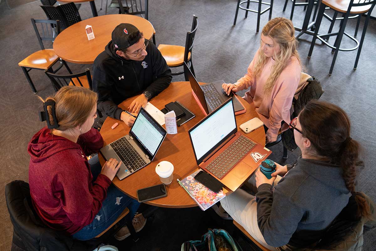 Four students working with laptops